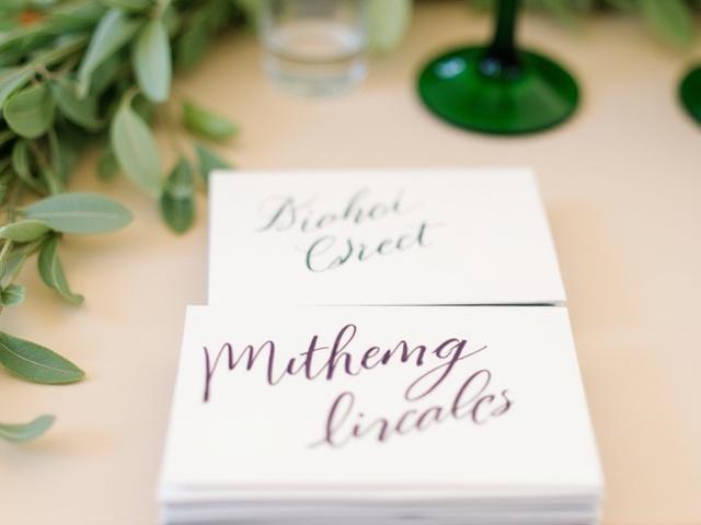 Artistically lettered place cards for a special event, arranged on a table with greenery